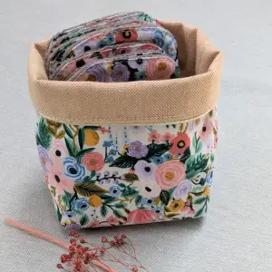 Lingettes lavables en coton bio rangées dans un panier en tissu
